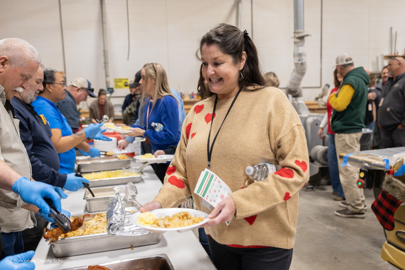 Woman getting plate of food from buffet