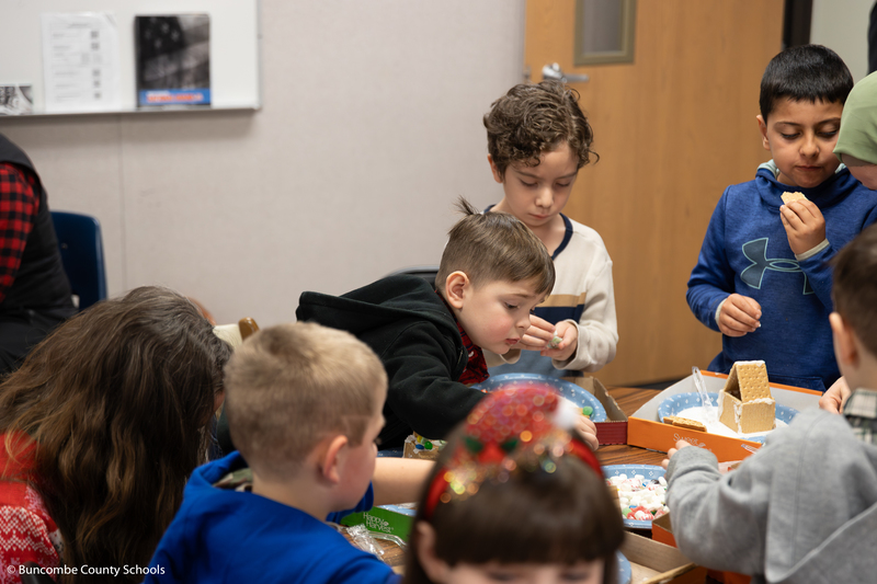 Photo of students all working diligently on their gingerbread houses.