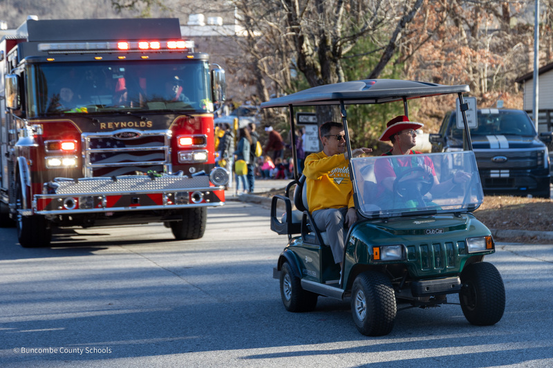 Dr. Jackson and Mr. Barnhouse ride in a golf cart in front of a Reynolds Fire Dept. fire truck