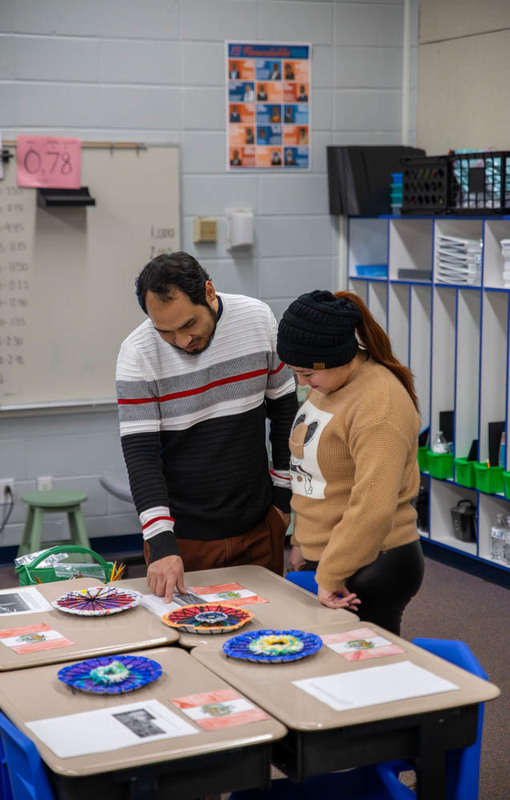 Students, teachers, and parents point at one of the presentations.