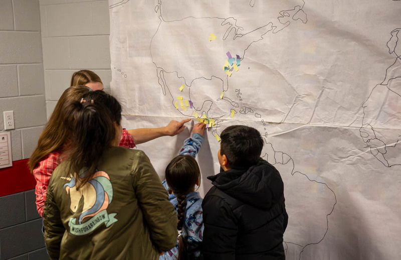 Students, teachers, and parents point at one of the presentations.