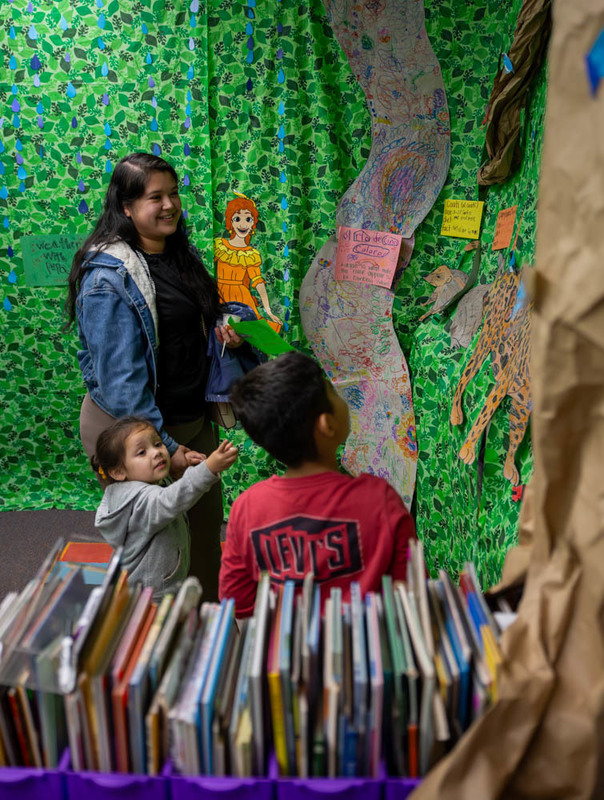 Students, teachers, and parents point at one of the presentations.