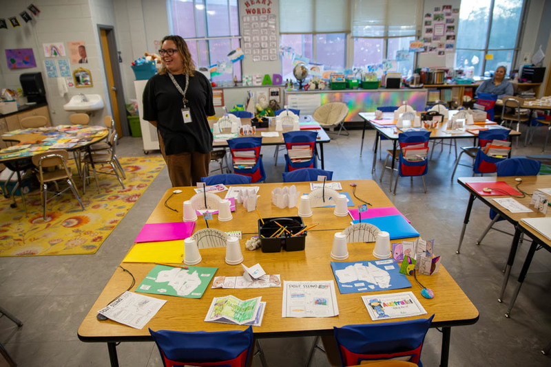 A teacher poses with classroom decorations.