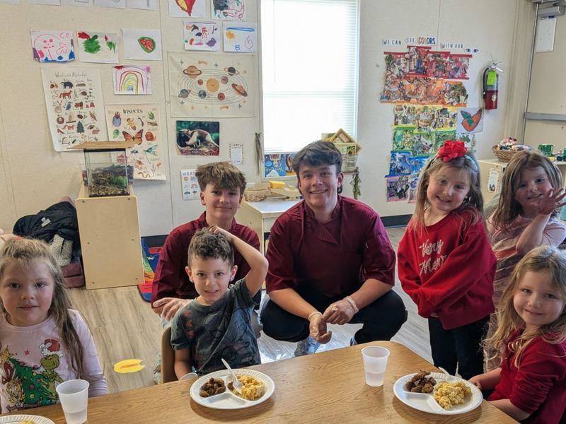 Family and Consumer Science Students sitting with the NC PreK students at Collins Early Learning Center. 