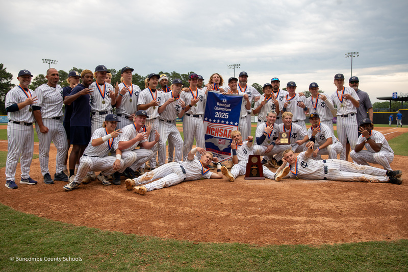 The Roberson baseball team poses on the field with a championship banner