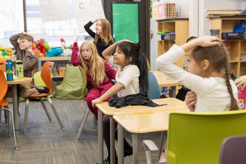 Students put one hand on their heads.