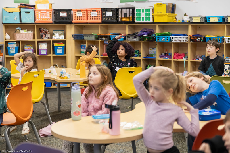 Students put one hand on their heads.