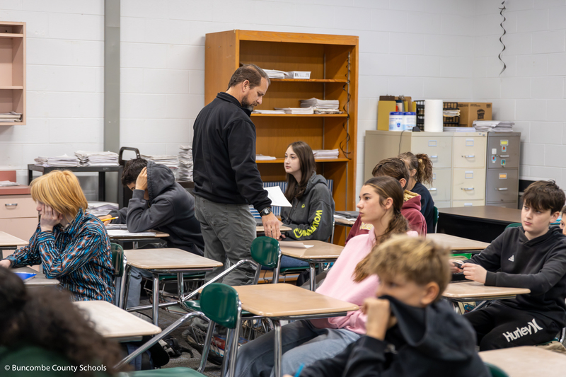 Mr. Gouge handing out paper to students. 