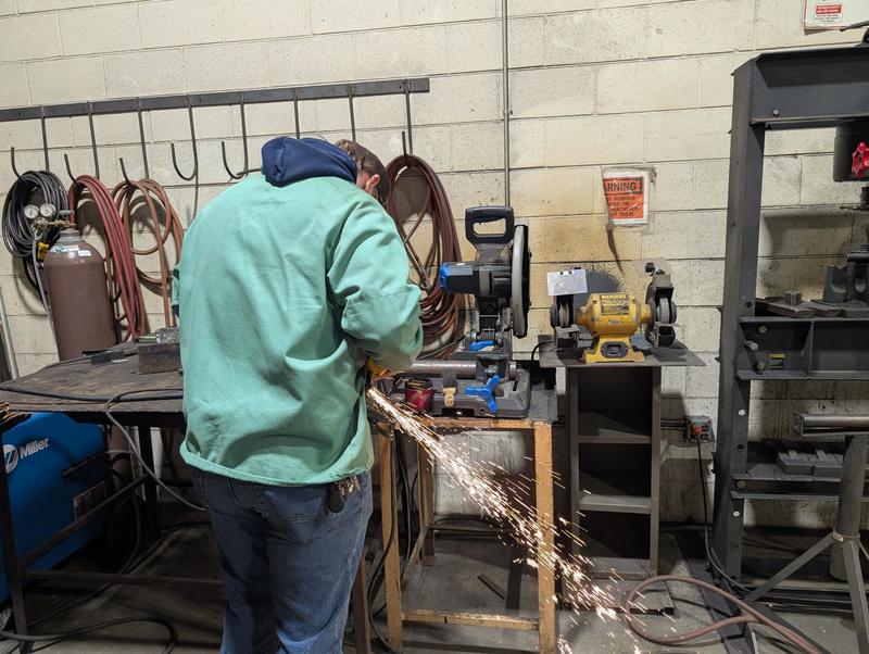 Sparks shower to the ground as a student welds in Mr. Fox's classroom.