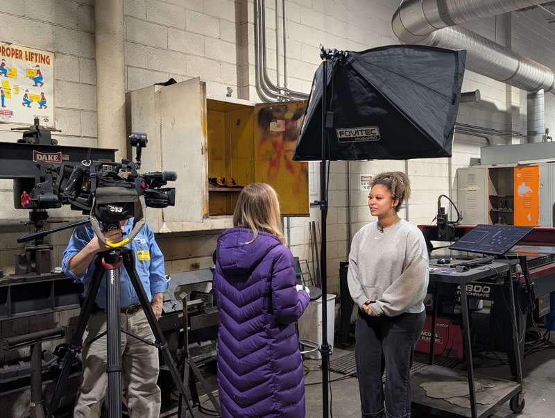 News 13's Karen Wynne interviews a student standing in front of a TV light.