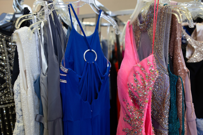 A close up shot of formal dresses hanging on a rack