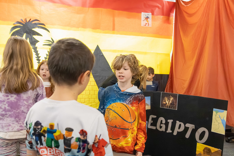 A student gives a presentation to a visitor.