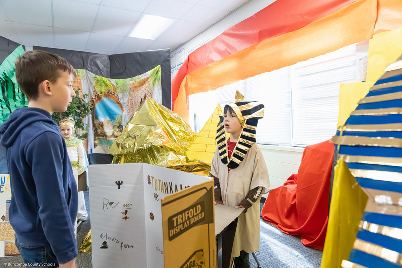 A student dressed as an ancient Egyptian speaks to visitors.