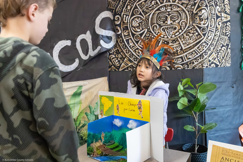 A student dressed as an ancient meso-American speaks to visitors.