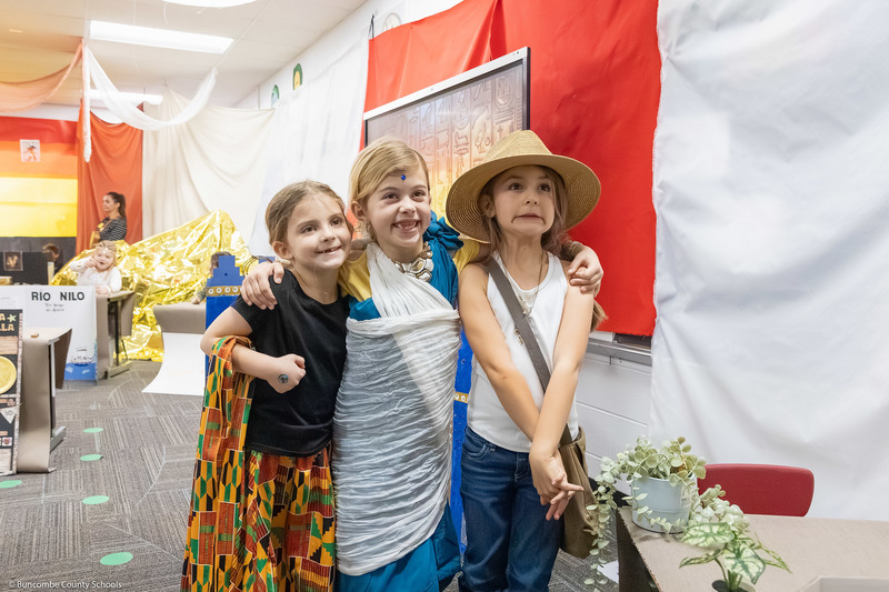 Three students smile while posing for a photo.