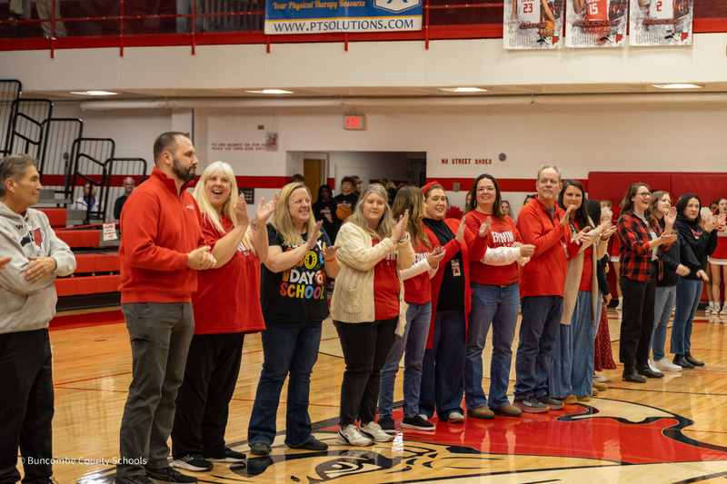 Erwin Teachers of the Year, principals,  and BCS leaders stand in a line on center court and clap