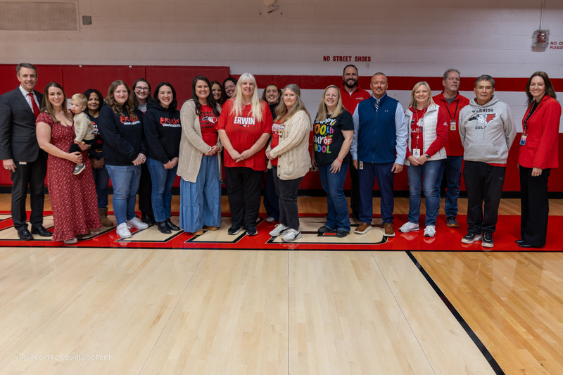 Erwin Teachers of the Year, principals,  and BCS leaders stand in a line on center court and clap