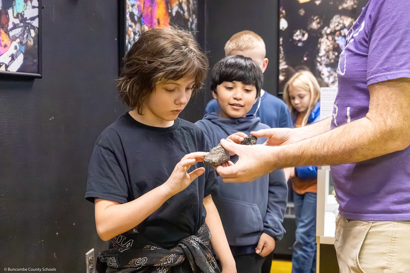 A student touches a Martian meteorite.