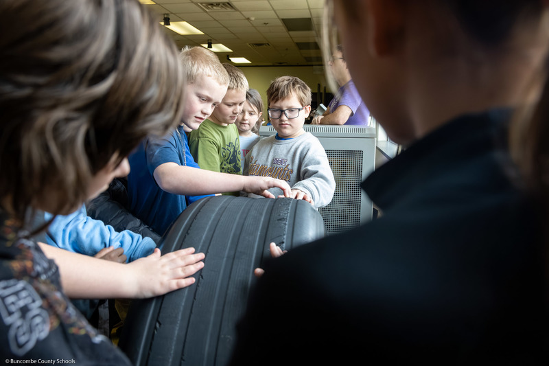 Students touch a wheel from a space shuttle.