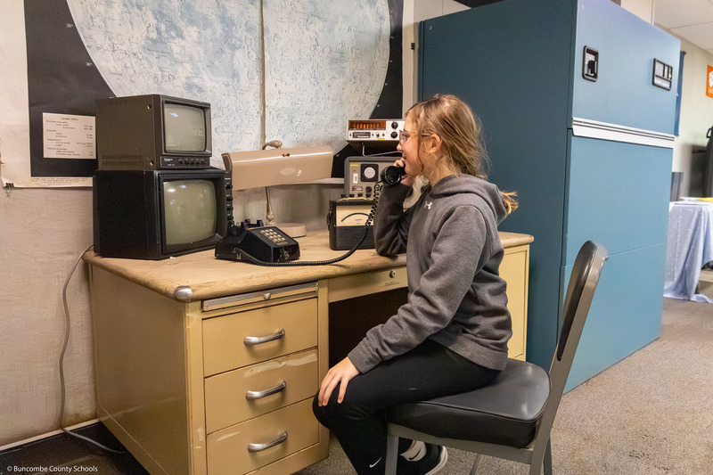A student sits at a replica monitoring station.