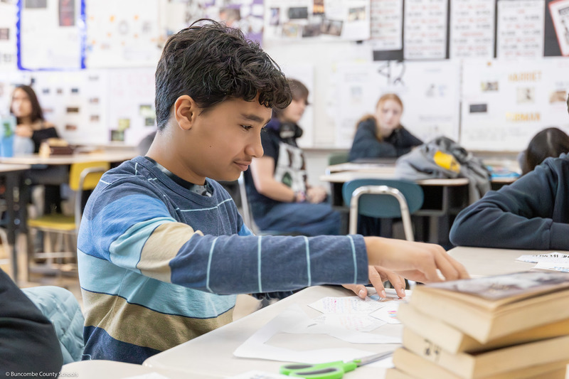 A student works on part of the quilt inside the classroom.