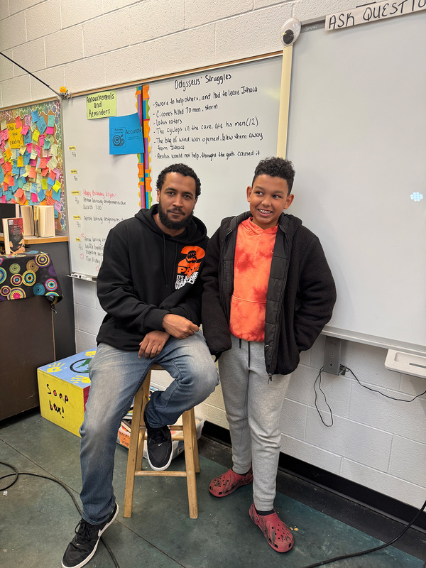 Student standing with Isa Ibn Wali for a photo.