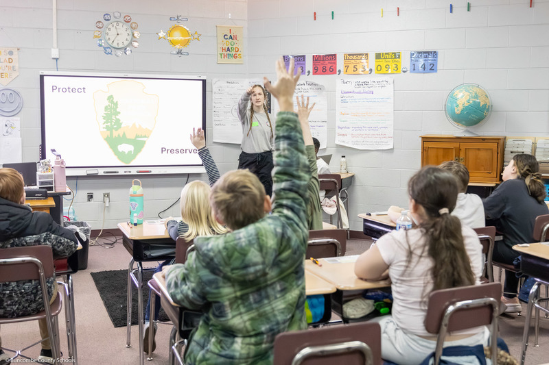 Students raise hands as a ranger points to one.