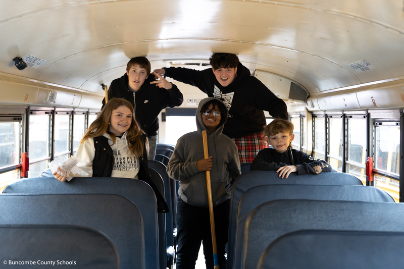 Group of students cleaning the bus. 