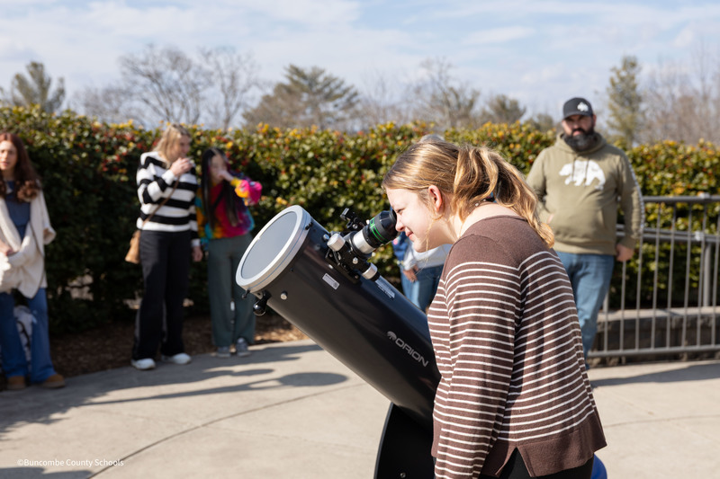 student looking through telescope