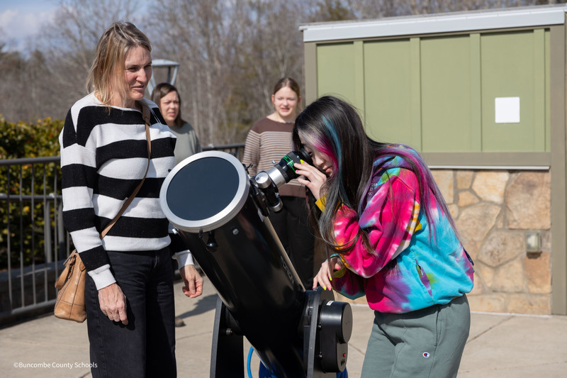 Student looking through telescope