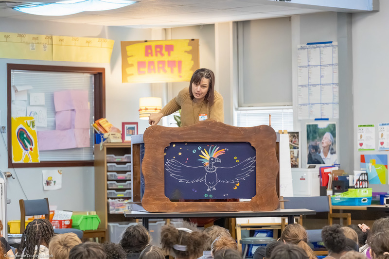 One of the two visitors performs a crankie box story.
