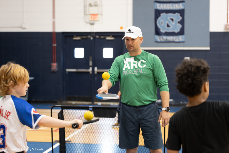 Instructor showing the students how to play pickleball.