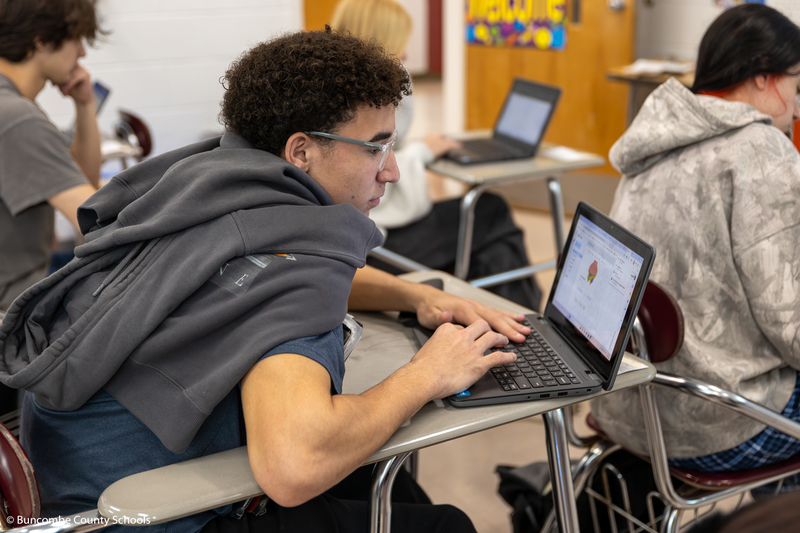 Student working on laptop and using math to create a digital artwork.