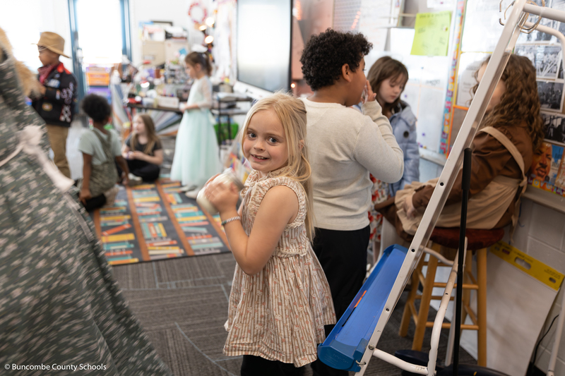 Student shaking a jar of heavy whipping cream and other ingredients  to make butter. 