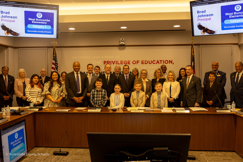 West Buncombe Elementary students and teachers stand with members of the state board of education, posing for a photo.