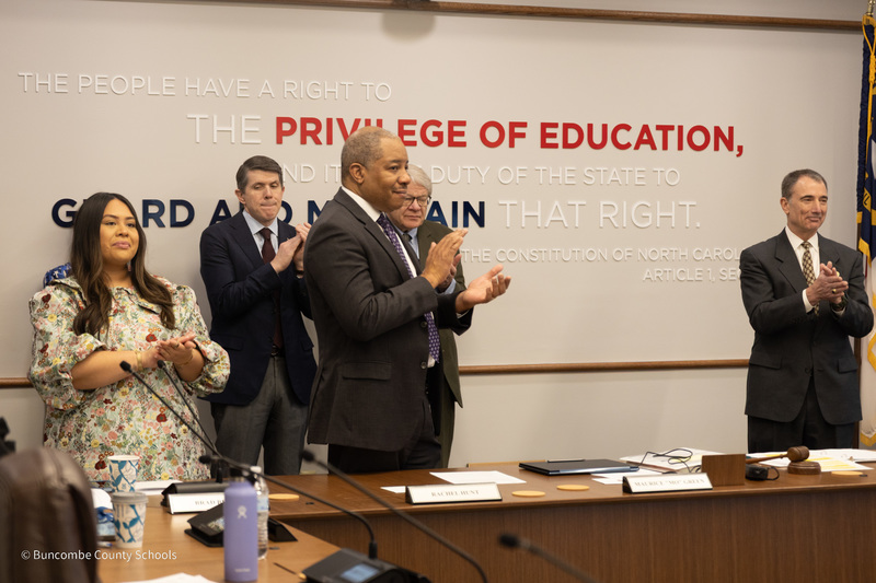 State Superintendent Mo Green stand and claps during the state board of education meeting