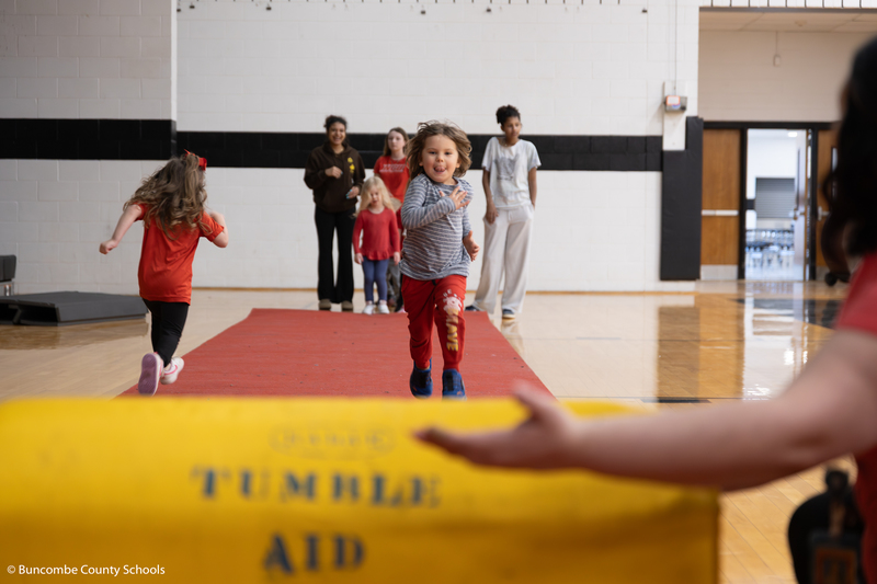 Preschooler running down a tumbling mat. 