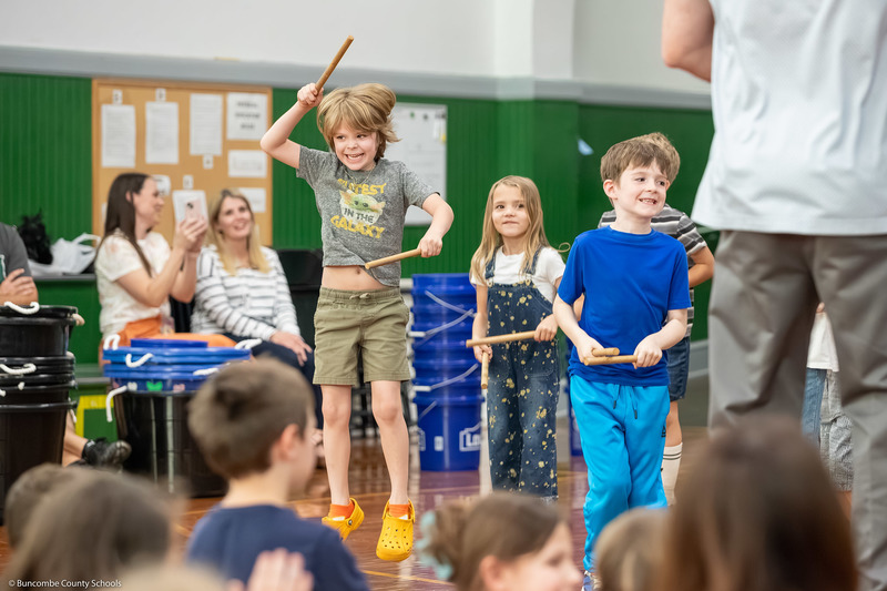 A student jumps and smiles during a performance.