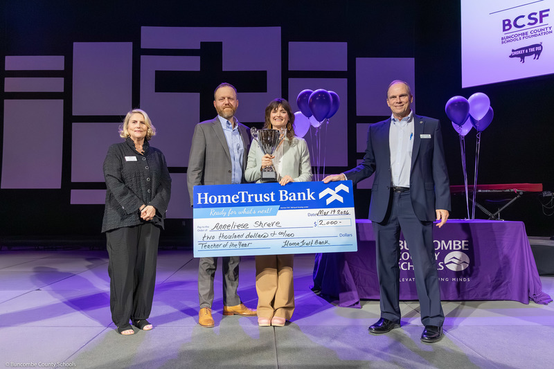 Ms. Cheek, Mr. and Ms. Sherve, and Mr. Gompers pose with a giant novelty check from HomeTrust Bank.