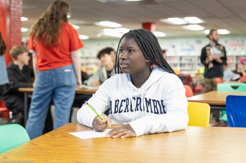 A student looks at a board while working on a math problem.