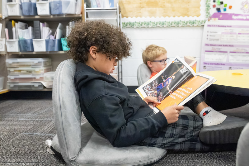 A third grade student reads a book.