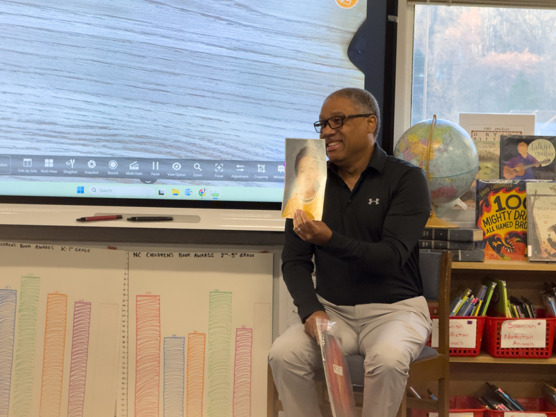 Rev. Charles Martin showing the students one of his school pictures from when he was a little boy. 