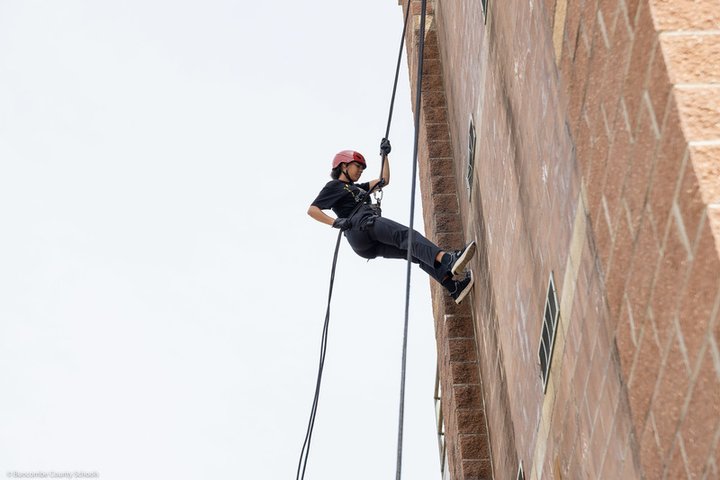 A student rappels down the tower.