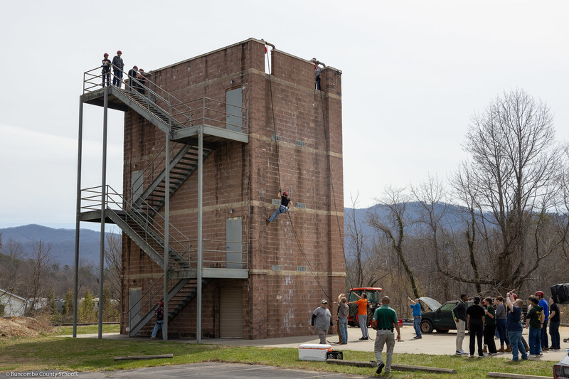 A photo showing the entire tower with a student rappelling down.