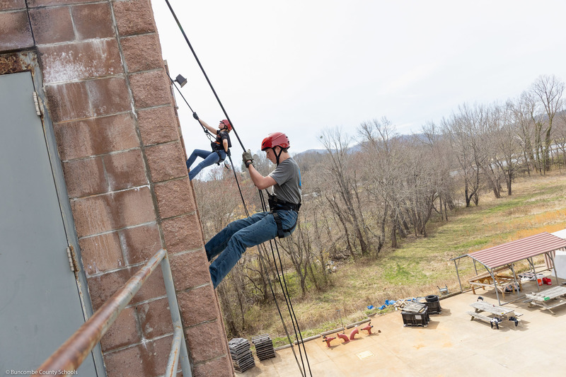 Two students rappel down the tower.