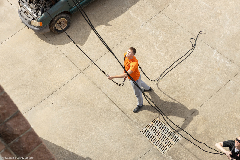 A belayer holds the rope for a cadet.