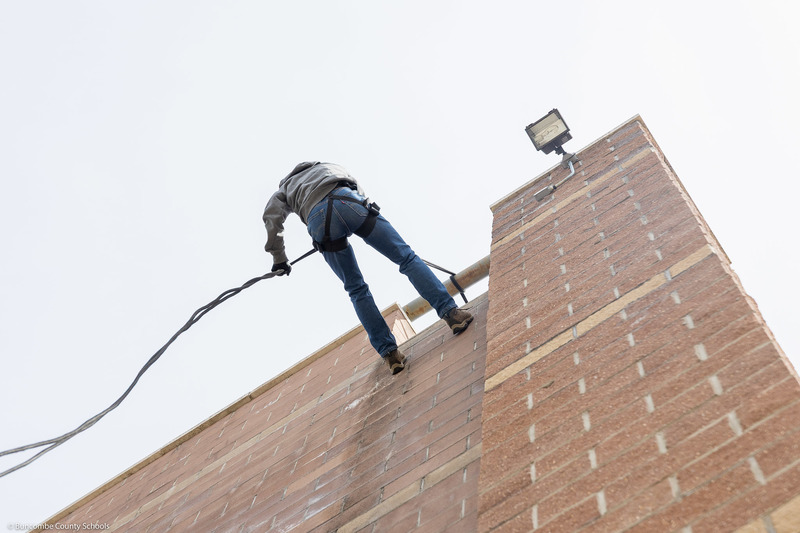 A student rappels down the tower.