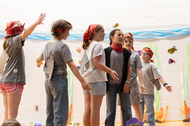 Students dressed as sharks singing