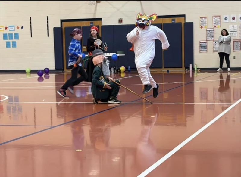 Students dressed as creatures performing a play in the gym. 