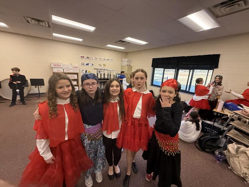 Group of students posing for the camera dressed in red, black and white. 